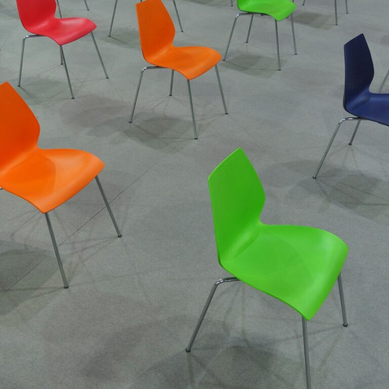 High angle shot of colorful chairs arranged with distance between them in rows